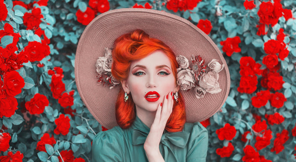 Beautiful women with red-orange hair, red lipstick, and wearing a sunhat.